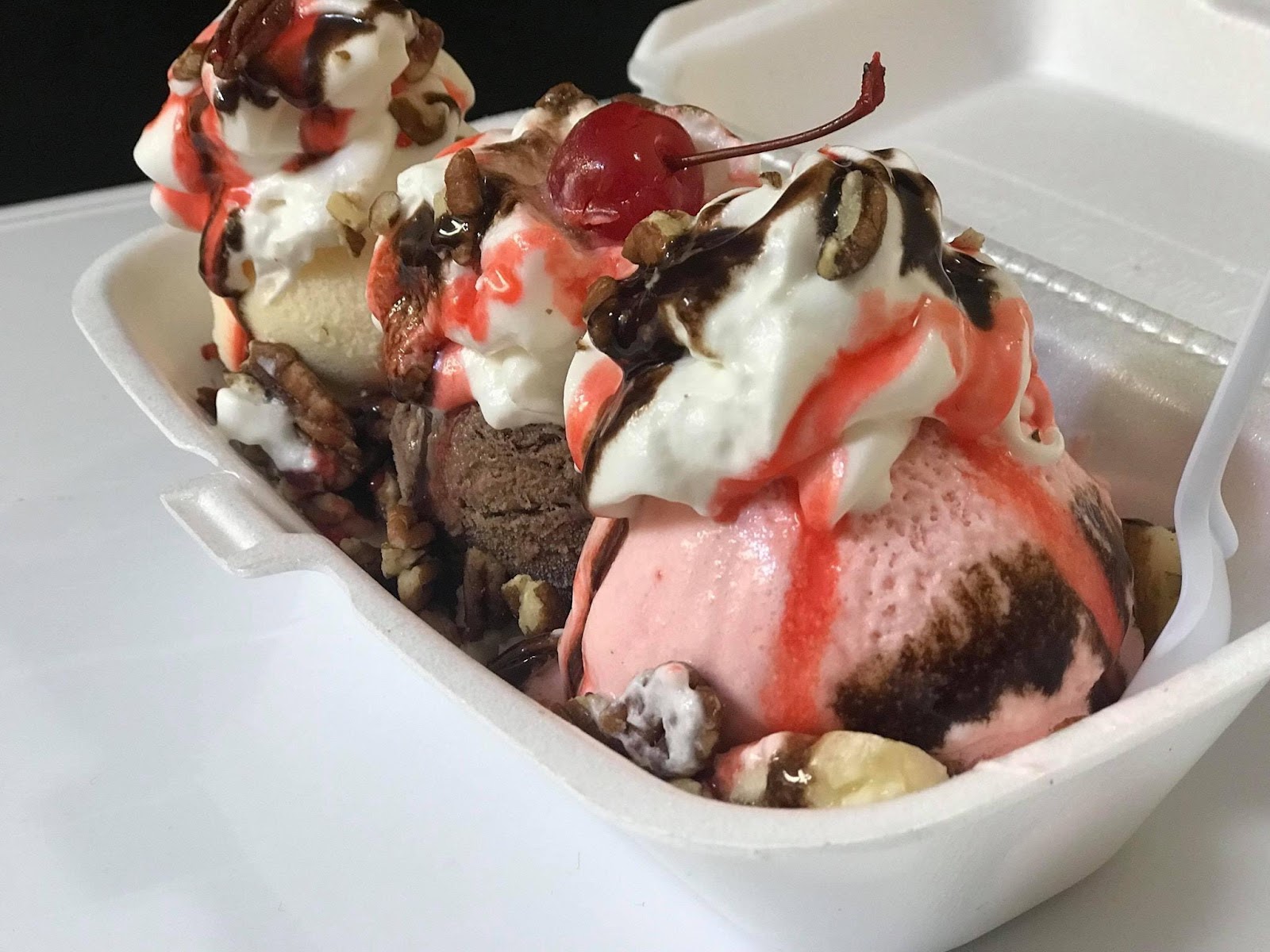 Ice cream sundae to go with pecans and cherry